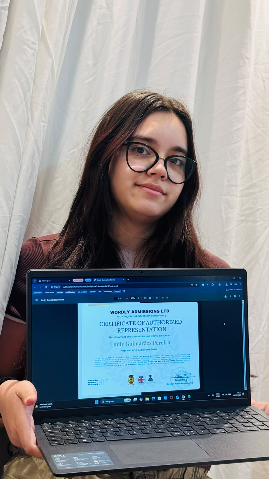 Emily Guimarães Pereira holding the Wordly Admissions certificate of authorized representation
