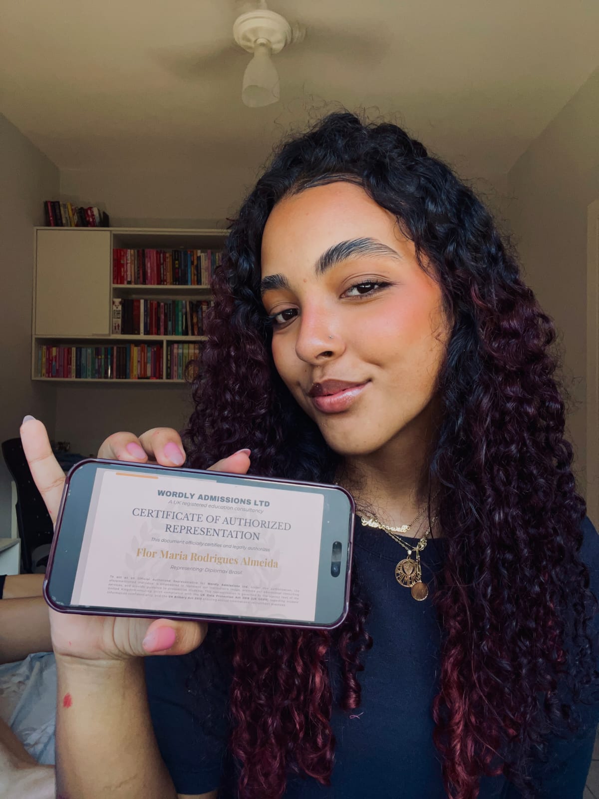 Flor Maria Rodrigues Almeida holding the Wordly Admissions certificate of authorized representation
