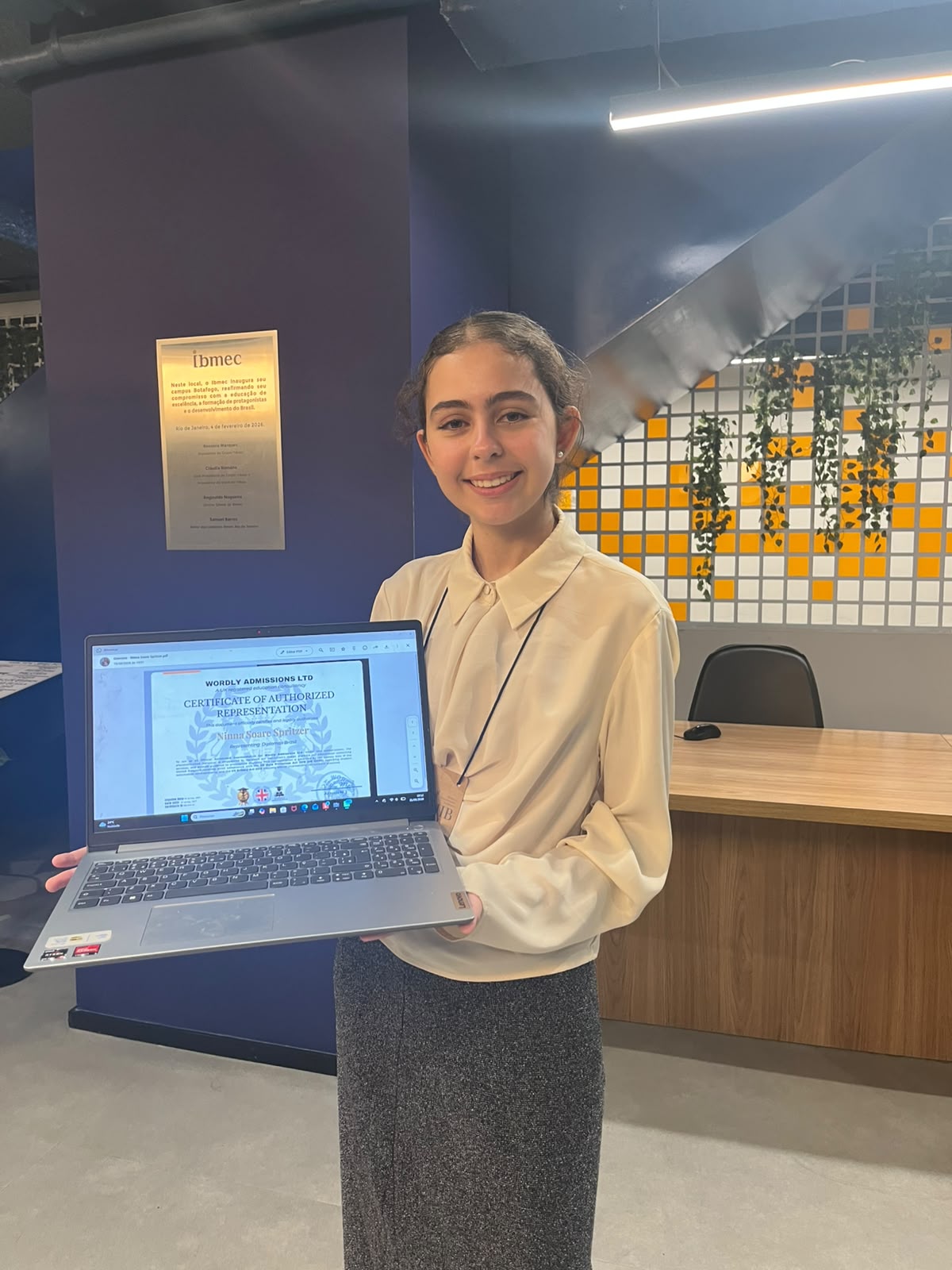 Ninna Soares Spritzer holding the Wordly Admissions certificate of authorized representation